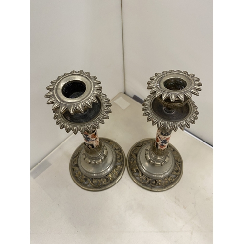 7 - A PAIR OF CANDLESTICKS WITH INTRICATE SCROLLWORK DETAIL WITH A DECORATIVE CERAMIC CENTRAL COLUMN