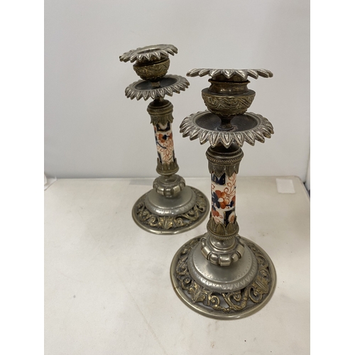7 - A PAIR OF CANDLESTICKS WITH INTRICATE SCROLLWORK DETAIL WITH A DECORATIVE CERAMIC CENTRAL COLUMN