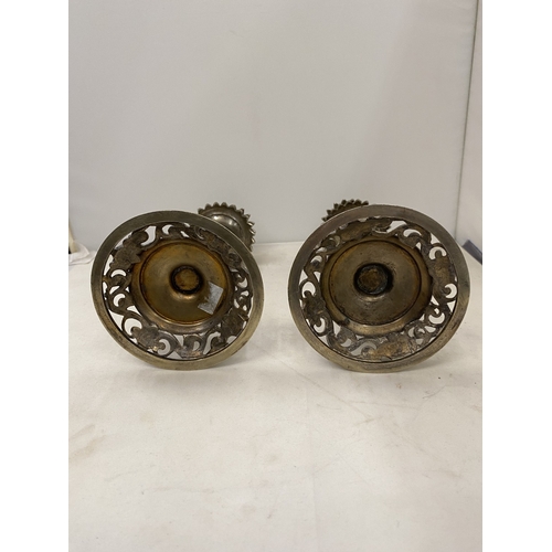 7 - A PAIR OF CANDLESTICKS WITH INTRICATE SCROLLWORK DETAIL WITH A DECORATIVE CERAMIC CENTRAL COLUMN