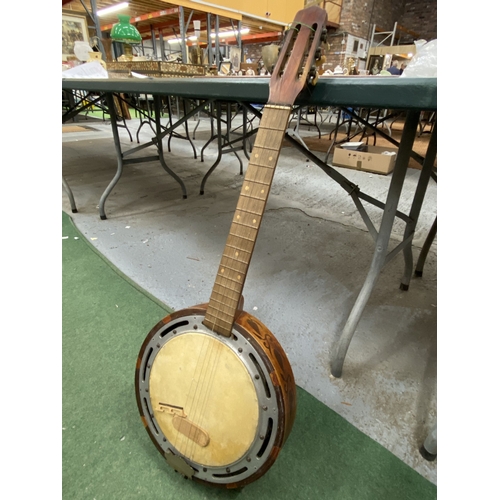 24 - A VINTAGE WOODEN BANJO WITH CARVING TO THE SIDES