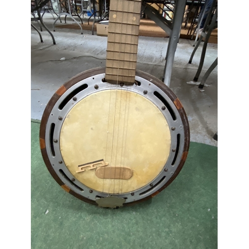 24 - A VINTAGE WOODEN BANJO WITH CARVING TO THE SIDES