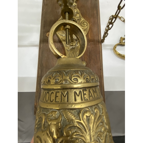 26 - A VINTAGE BRASS BELL ON AN ORNATE BRACKET AND WOODEN PLINTH