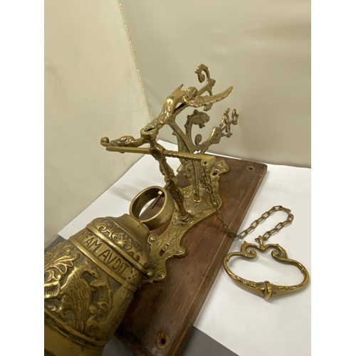 26 - A VINTAGE BRASS BELL ON AN ORNATE BRACKET AND WOODEN PLINTH