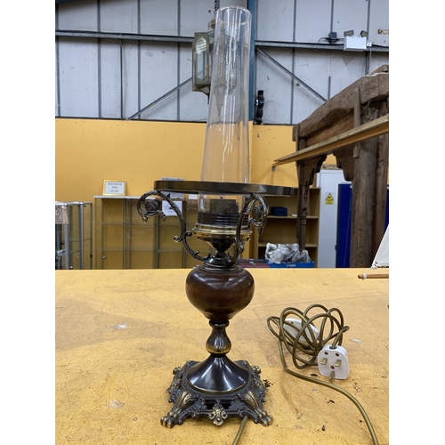 38 - A VINTAGE STYLE METAL AND WOODEN TABLE LAMP IN THE STYLE OF AN OIL LAMP WITH GLASS CHIMNEY AS THE SH... 