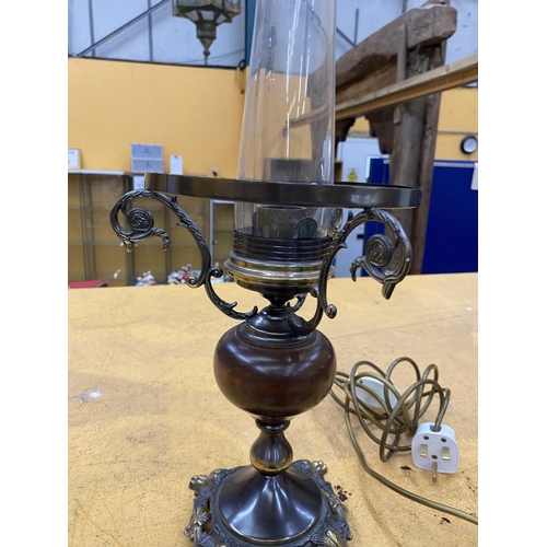 38 - A VINTAGE STYLE METAL AND WOODEN TABLE LAMP IN THE STYLE OF AN OIL LAMP WITH GLASS CHIMNEY AS THE SH... 