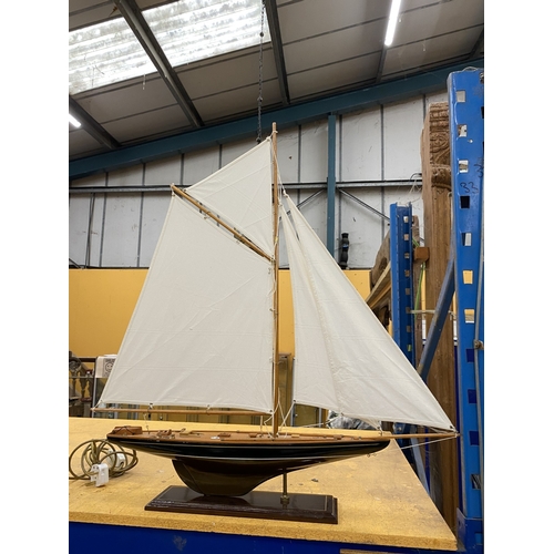 39 - A LARGE WOODEN MODEL OF A YACHT, ON A WOODEN PLINTH, HEIGHT 85CM, LENGTH 74CM
