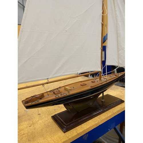 39 - A LARGE WOODEN MODEL OF A YACHT, ON A WOODEN PLINTH, HEIGHT 85CM, LENGTH 74CM