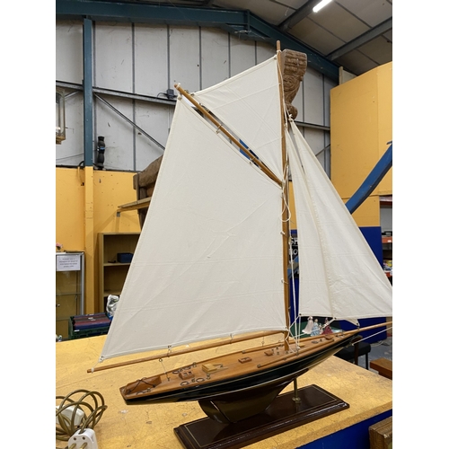 39 - A LARGE WOODEN MODEL OF A YACHT, ON A WOODEN PLINTH, HEIGHT 85CM, LENGTH 74CM