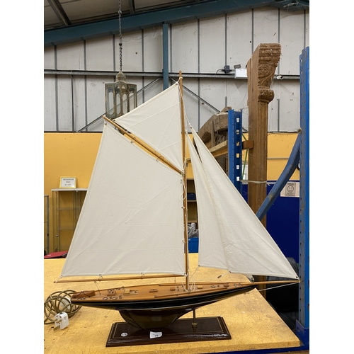 39 - A LARGE WOODEN MODEL OF A YACHT, ON A WOODEN PLINTH, HEIGHT 85CM, LENGTH 74CM