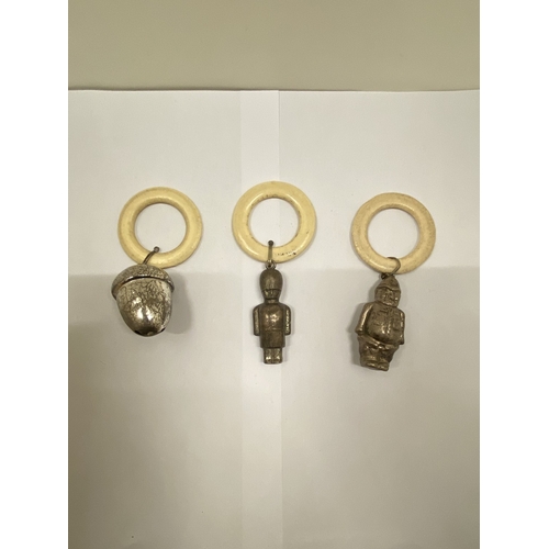 40 - THREE VINTAGE WHITE METAL RATTLES, AN ACORN, POLICEMAN AND SOLDIER
