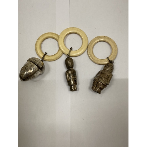 40 - THREE VINTAGE WHITE METAL RATTLES, AN ACORN, POLICEMAN AND SOLDIER