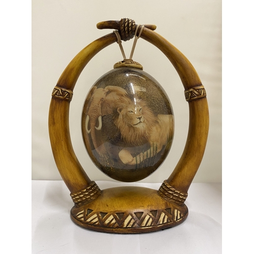 47 - A HAND PAINTED OSTRICH EGG WITH A LION PICTURE ON A HORN STAND