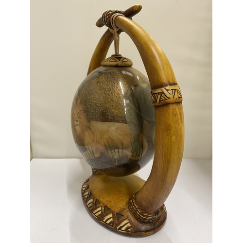 47 - A HAND PAINTED OSTRICH EGG WITH A LION PICTURE ON A HORN STAND