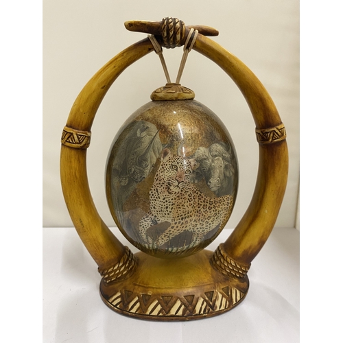 47 - A HAND PAINTED OSTRICH EGG WITH A LION PICTURE ON A HORN STAND