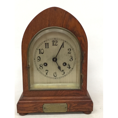 9 - A VINTAGE OAK, GOTHIC STYLE CHIMING MANTLE CLOCK, WITH A PRESENTATION PLAQUE TO THE FRONT FOR 1920