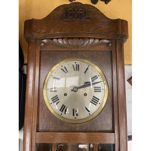 21 - A WESTMINSTER CHIMING OAK CASED WALL CLOCK WITH PENDULUM AND KEY
