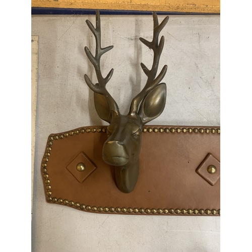 42 - A PAIR OF BRASS STAGS HEAD MOUNTED ON A LEATHER BOARD