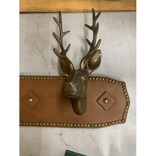 42 - A PAIR OF BRASS STAGS HEAD MOUNTED ON A LEATHER BOARD