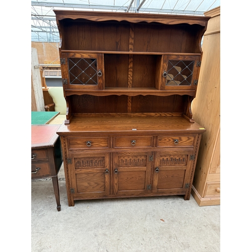 2536 - A JAYCEE OAK DRESSER WITH RACK ENCLOSING TWO GLAZED AND LEADED DOORS, 54
