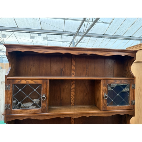 2536 - A JAYCEE OAK DRESSER WITH RACK ENCLOSING TWO GLAZED AND LEADED DOORS, 54
