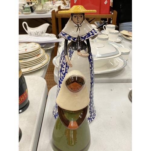 143 - A BLUE AND WHITE CERAMIC BELL GIRL WITH A YELLOW HAT TOGETHER WITH A JIE KERAMIK GANTOFTA STYLE CERA... 