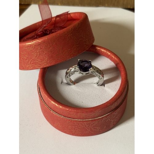 600 - A MARKED 925 PURPLE STONE AND CUBIC ZIRCONIA RING SIZE N IN A PRESENTATION BOX