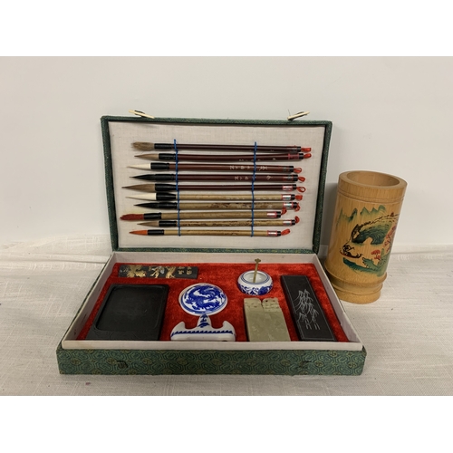 312 - A VINTAGE CHINESE CALLIGRAPHY SET TO INCLUDE A VARIETY OF BRUSHES, INK STONE, PORCELAIN WATER POT ET... 