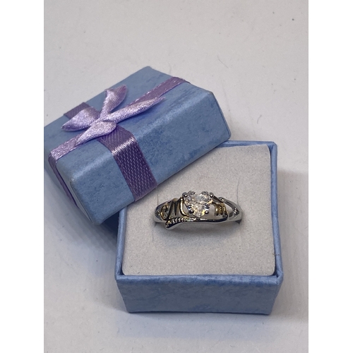 695 - A MARKED 925 MUM RING WITH HEART SHAPED CENTRE CLEARSTONE IN A PRESENTATION BOX