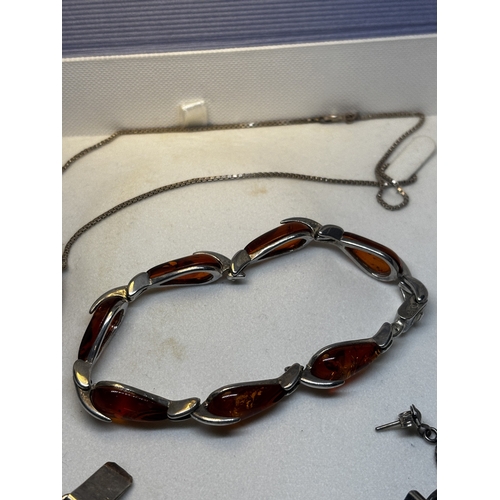 527 - FOUR SILVER AND AMBER ITEMS TO INCLUDE TWO BRACELETS, A PAIR OF EARRINGS AND A PENDANT ON A SILVER C... 