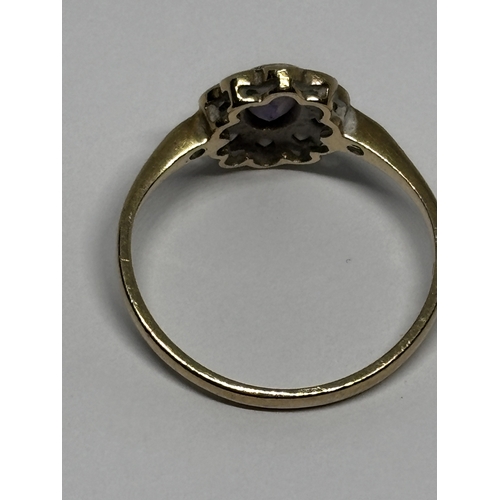 529 - A MARKED 9 CARAT GOLD RING WITH CENTRE AMETHYST SURROUNDED BY TEN DIAMONDS WITH DIAMOND CHIPS TO THE... 