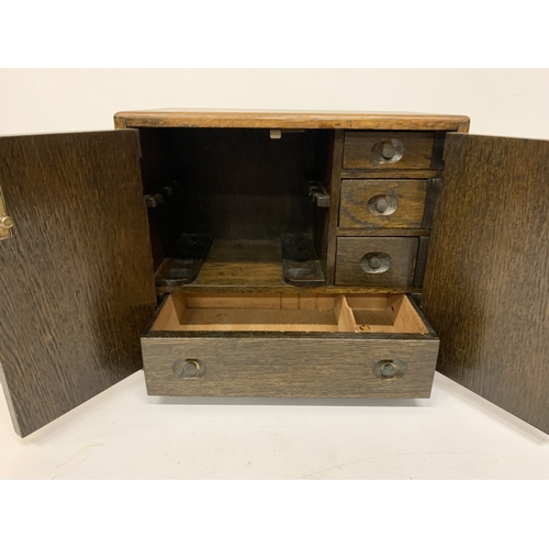17 - A VINTAGE OAK SMOKERS CABINET WITH INNER DRAWERS AND PIPE RACK