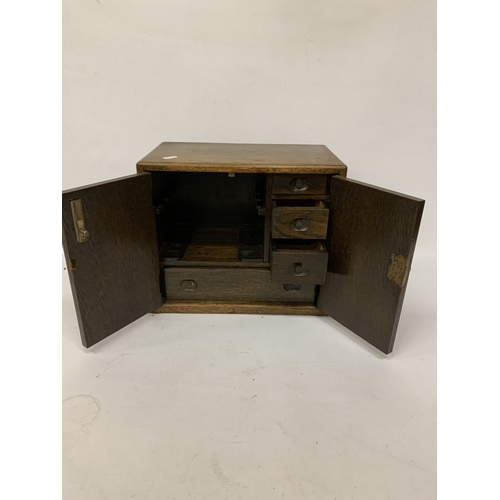 17 - A VINTAGE OAK SMOKERS CABINET WITH INNER DRAWERS AND PIPE RACK