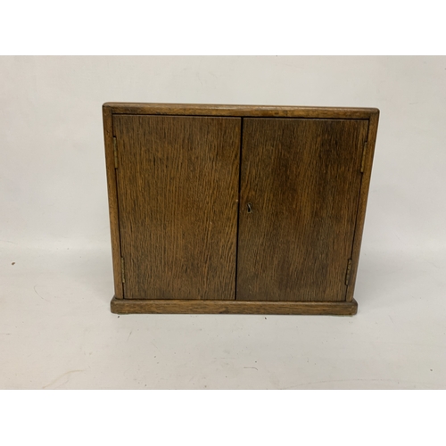 17 - A VINTAGE OAK SMOKERS CABINET WITH INNER DRAWERS AND PIPE RACK