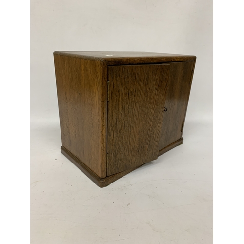 17 - A VINTAGE OAK SMOKERS CABINET WITH INNER DRAWERS AND PIPE RACK