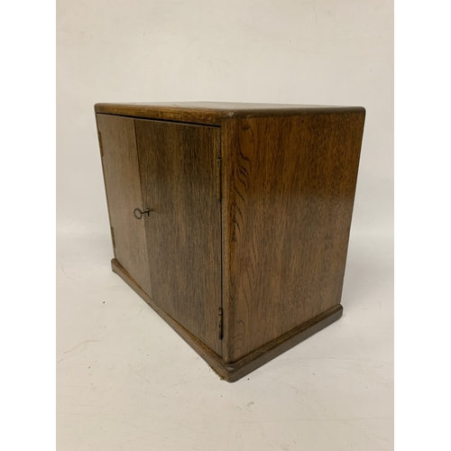 17 - A VINTAGE OAK SMOKERS CABINET WITH INNER DRAWERS AND PIPE RACK