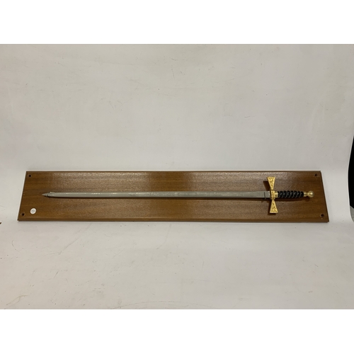 37 - AN ORNAMENTAL WILKINSON SWORD ON A WOODEN BASE, LENGTH 92CM