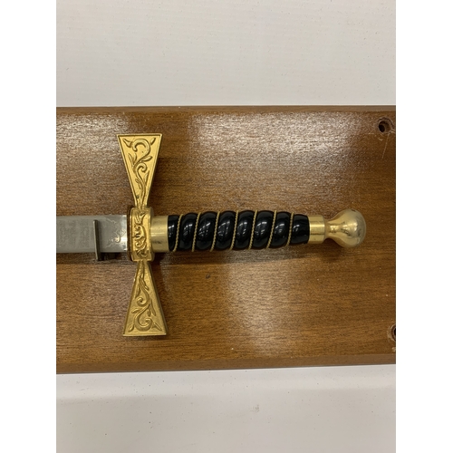 37 - AN ORNAMENTAL WILKINSON SWORD ON A WOODEN BASE, LENGTH 92CM