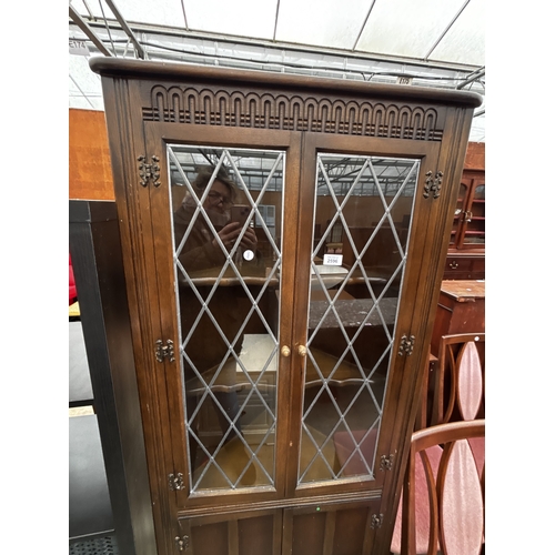 2596 - A PRIORY OAK CORNER CUPBOARD WITH GLAZED AND LEADED UPPER PORTION, 27