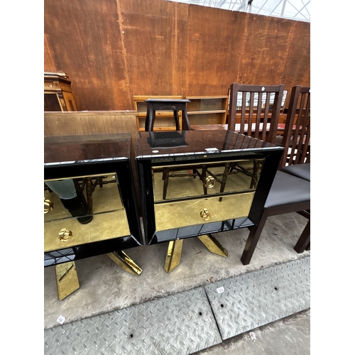 2612 - A PAIR OF BLACK GLASS BEDSIDE CHESTS EACH WITH TWO GOLD COLOURED DRAWERS AND MIRRORED LEGS