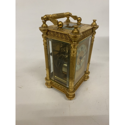79 - A FRENCH GILT BRASS CARRIAGE CLOCK WITH REEDED COLUMNS, ORNATE GILT FRETWORK PANELS, ENAMEL CHAPTER ... 