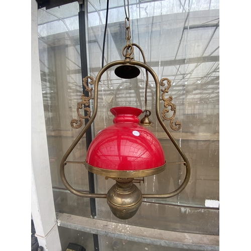 1538 - A PAIR OF VINTAGE BRASS CEILING LIGHT FITTINGS WITH RED GLASS SHADES
