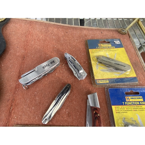1606 - SEVEN POCKET KNIVES TO INCLUDE THREE NEW AND PACKAGED MARKSMAN, THREE OF WHICH ARE MULTITOOLS AND A ... 