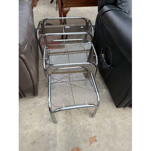 2802 - A TUBULAR CHROME AND GLASS NEST OF THRE TABLES