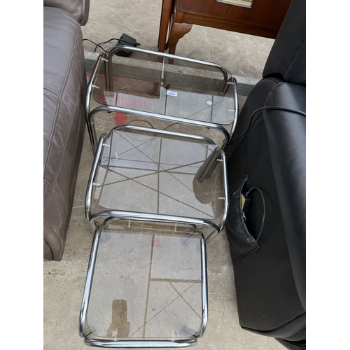 2802 - A TUBULAR CHROME AND GLASS NEST OF THRE TABLES