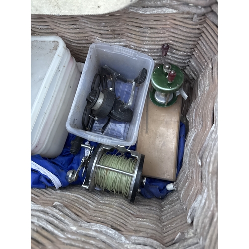 1711 - A WICKER FISHING TACKLE BASKET WITH AN ASSORTMENT OF FISHING TACKLE TO INCLUDE REELS AND FLOATS ETC