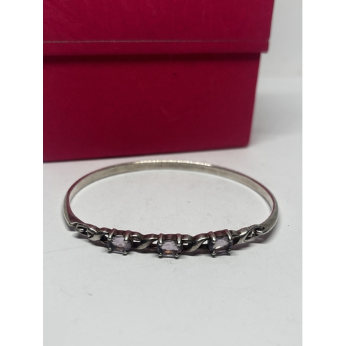 562 - AN AMETHYST BANGLE GROSS WEIGHT 12.01 GRAMS IN A PRESENTATION BOX