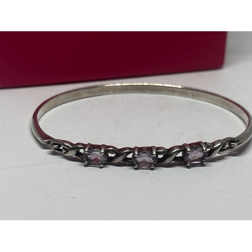 562 - AN AMETHYST BANGLE GROSS WEIGHT 12.01 GRAMS IN A PRESENTATION BOX