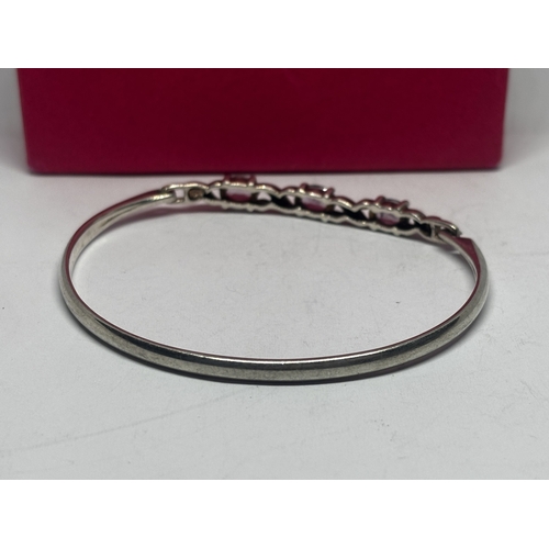 562 - AN AMETHYST BANGLE GROSS WEIGHT 12.01 GRAMS IN A PRESENTATION BOX