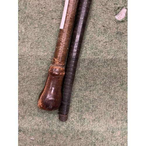 25 - TWO ITEMS - A LATE 19TH/EARLY 20TH CENTURY WEIGHTED WALKING CANE WITH SEGMENTED LEATHER SHAFT WITH P... 