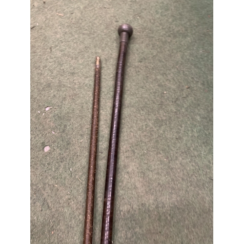 25 - TWO ITEMS - A LATE 19TH/EARLY 20TH CENTURY WEIGHTED WALKING CANE WITH SEGMENTED LEATHER SHAFT WITH P... 